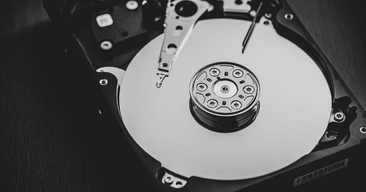 A white and silver external hard disk drive on a desk