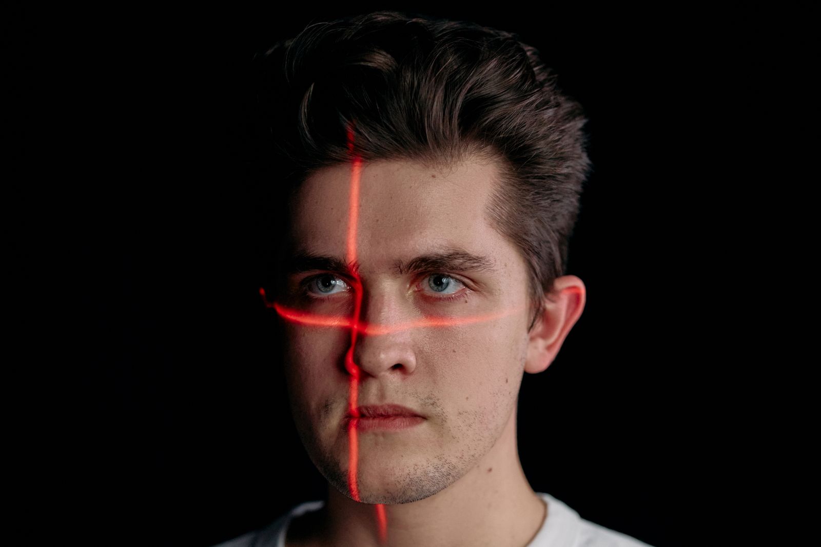 A portrait with laser scanning lines across the face, representing deepfake detection